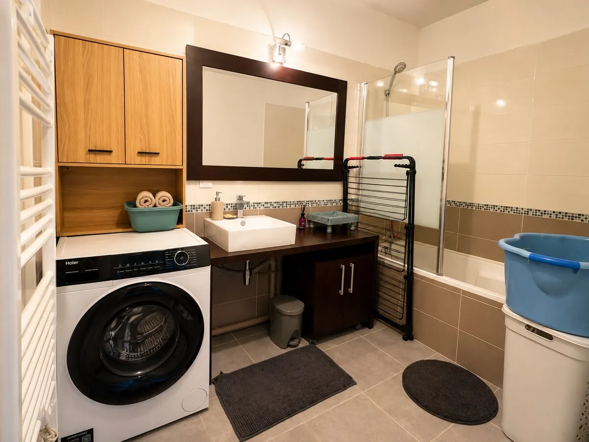 Salle de bain avec baignoire et lave-linge à Jacou