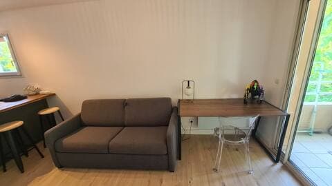 Canapé et espace de travail du studio aux Arceaux