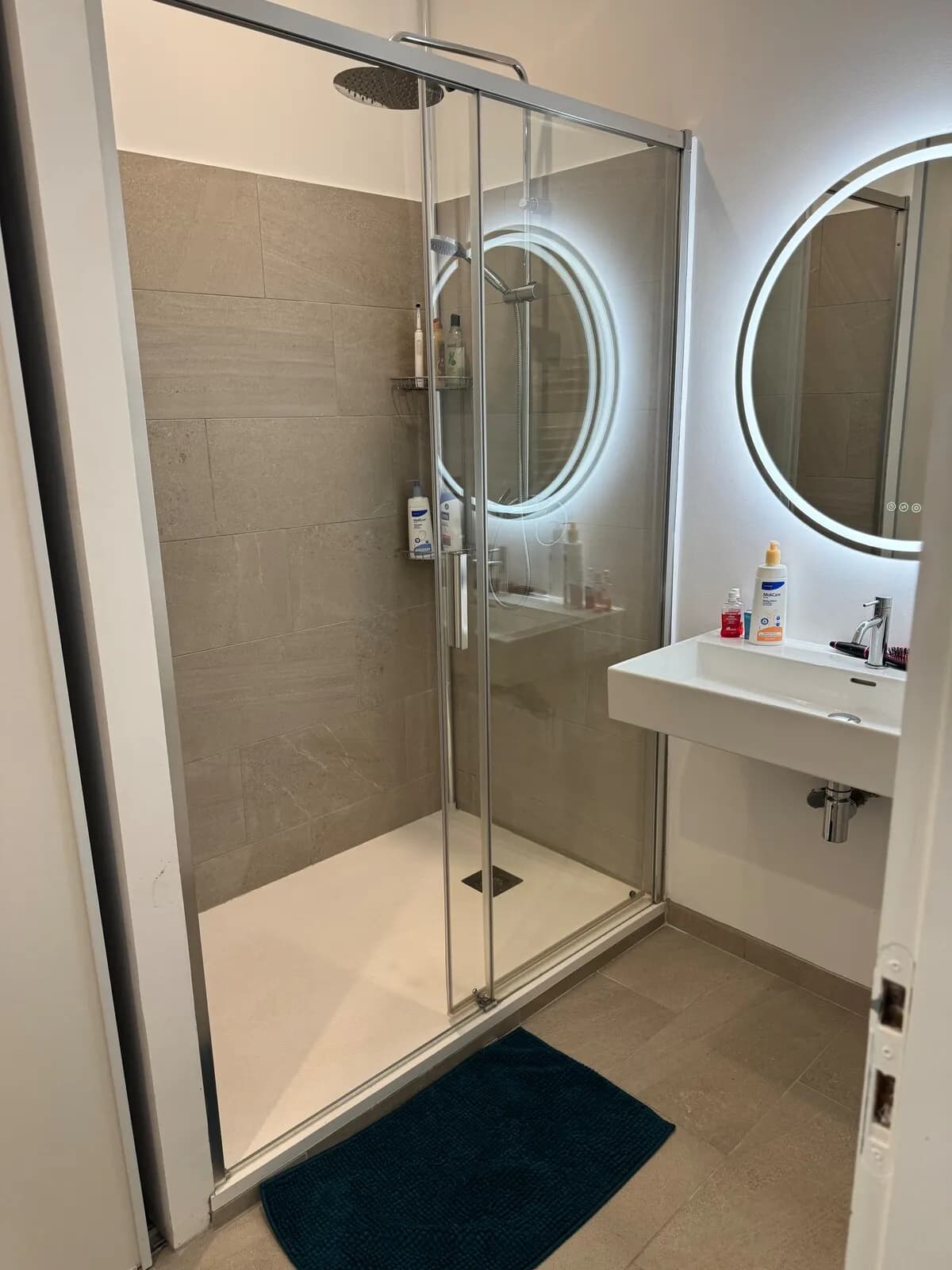 Salle d'eau avec double douche et miroirs ronds à Montferrier-sur-Lez
