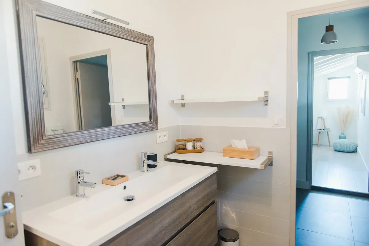 Salle de bains avec vasque et grand miroir
